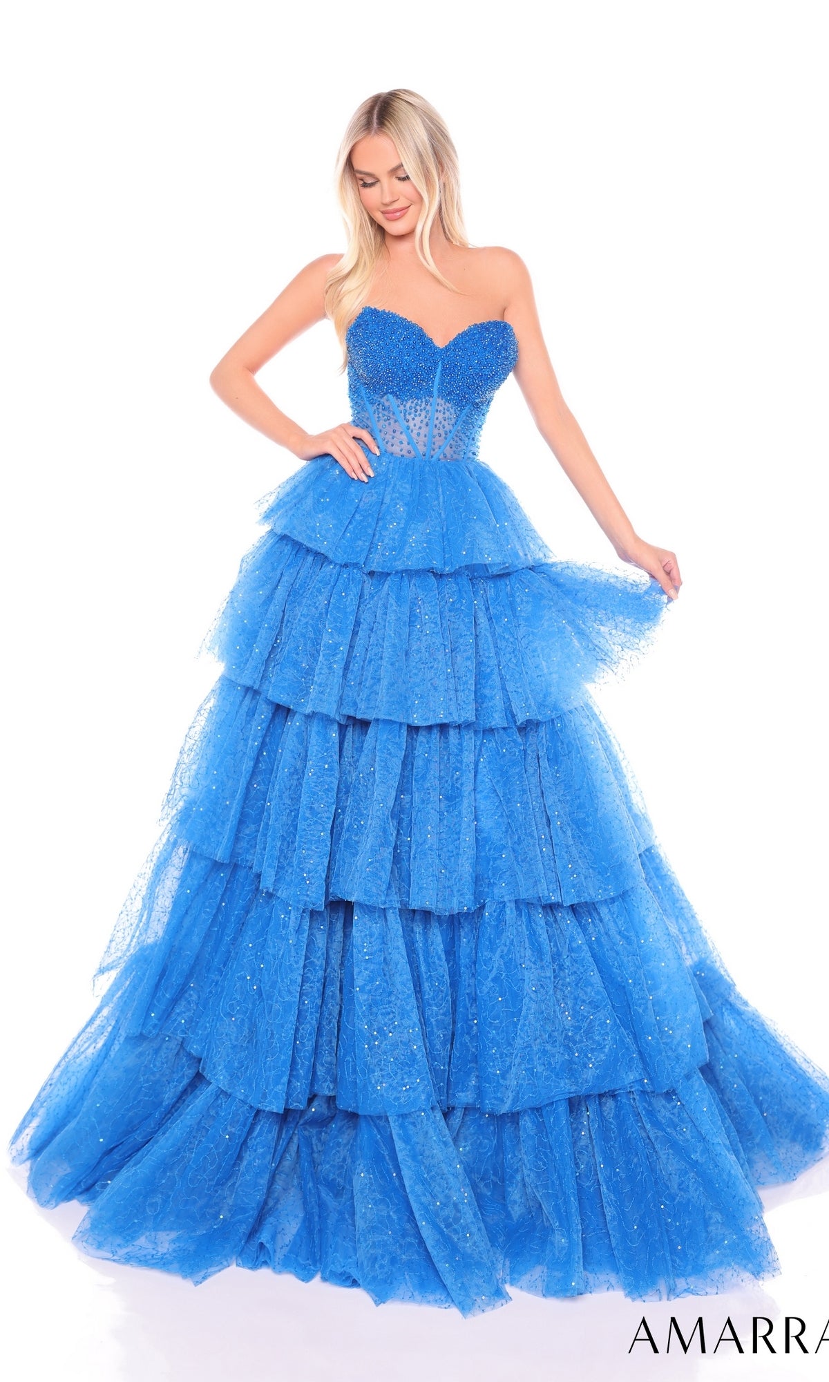 A woman in the Long Formal Dress 88131 by Amarra, featuring a strapless design with ruffle layered tiers and glitter detail, stands against a white background.